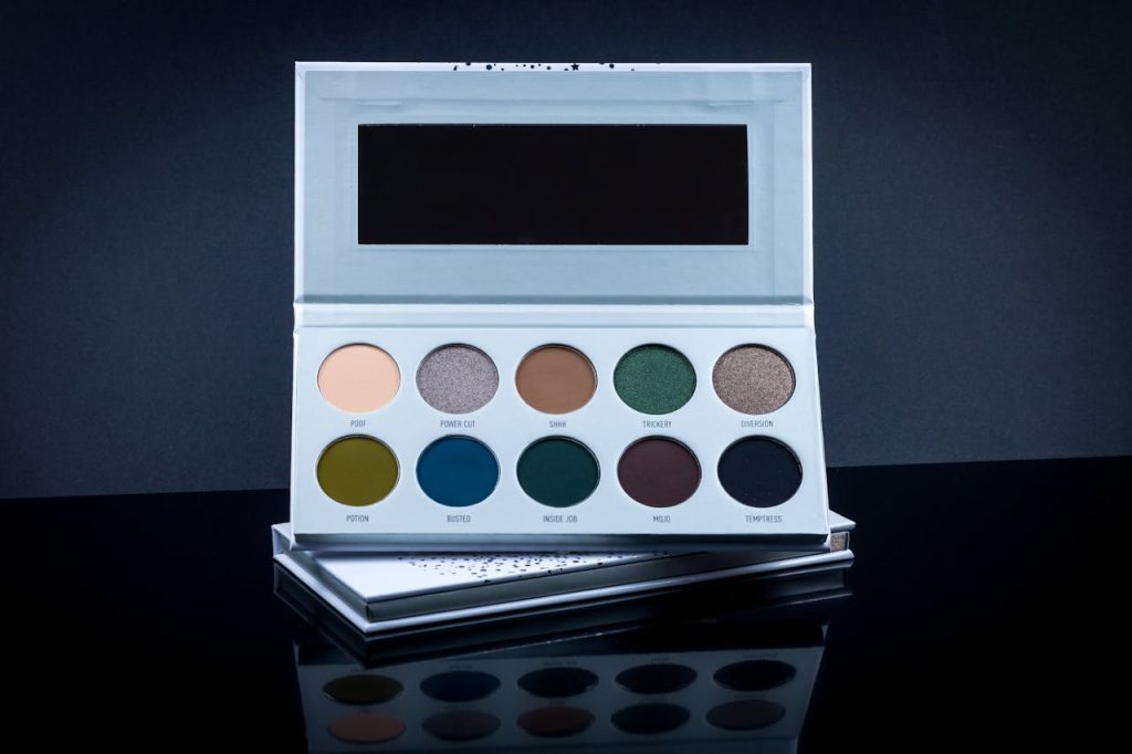 Chic eyeshadow palette displaying a range of vibrant colors on a sleek, mirrored surface.